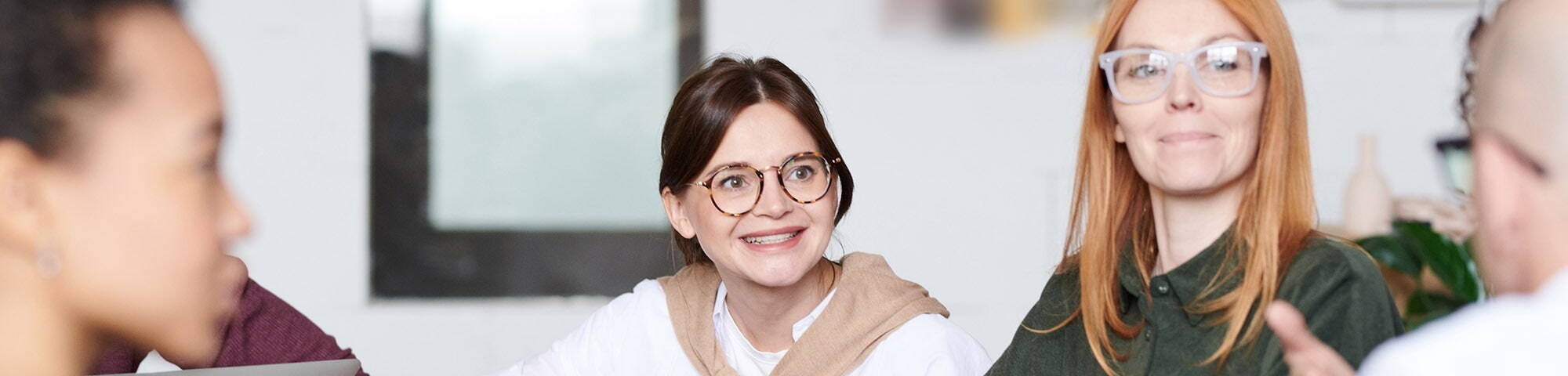 Female with glasses sat with other people