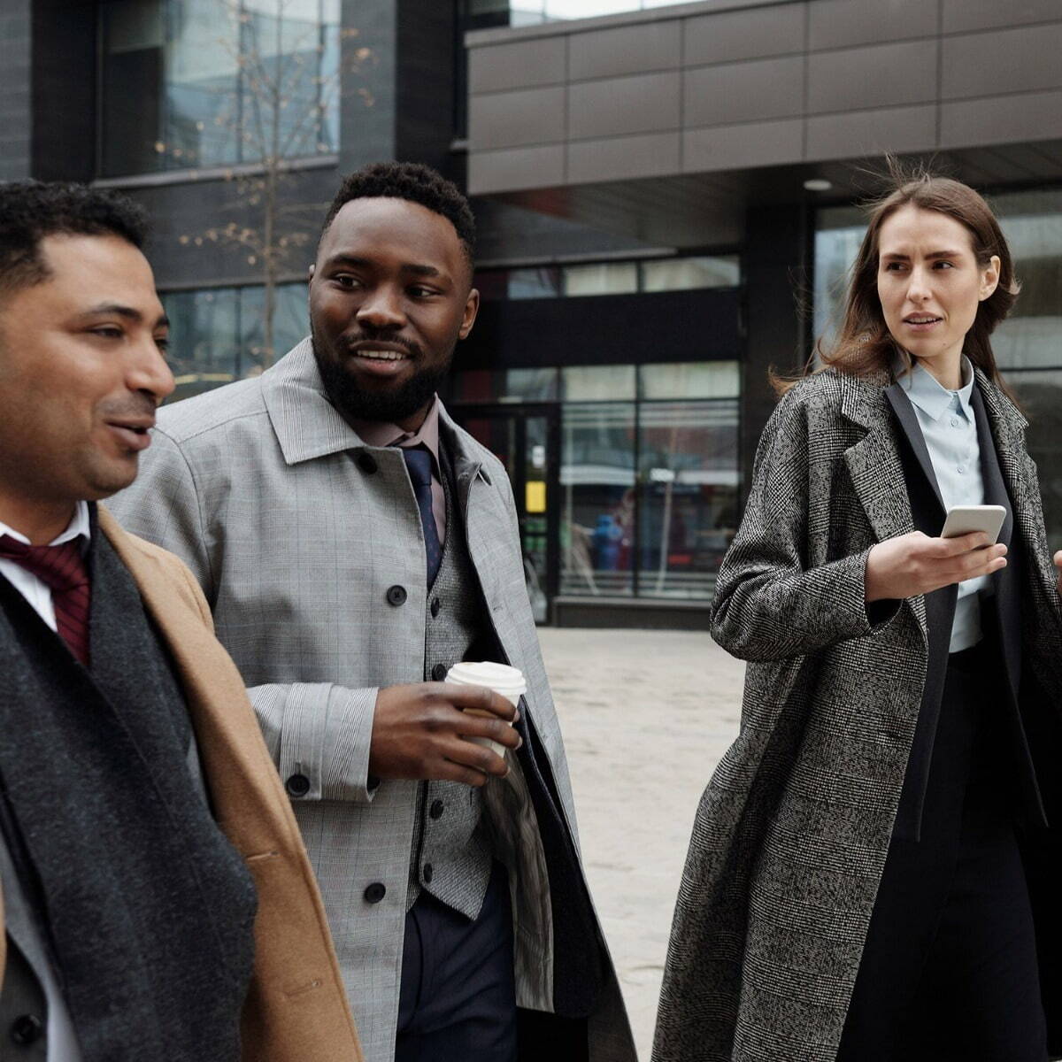 Three people walking together dressed smartly 